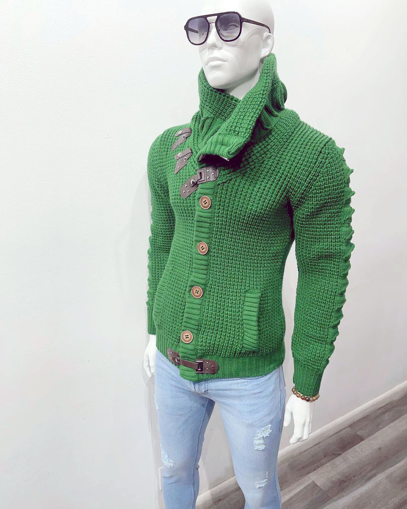 White mannequin wearing sunglasses, a green high-collar cardigan sweater, and light blue distressed jeans.