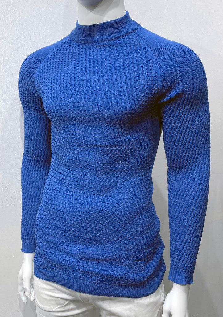 Royal blue long-sleeve, turtleneck sweater with raglan sleeve design as seen from the front. There is a waffle weave pattern woven into the knit fabric.