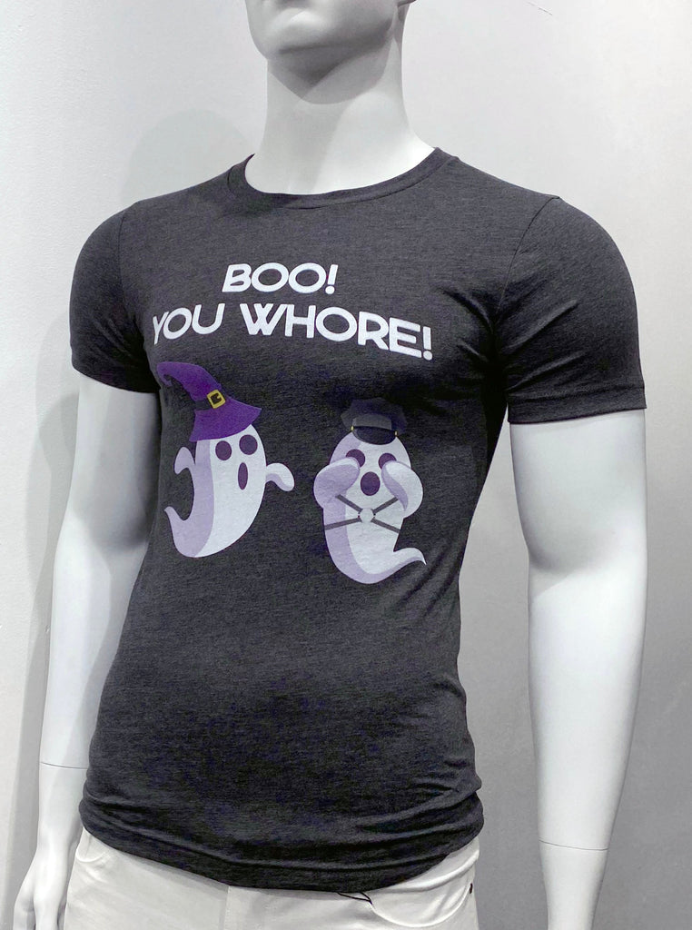 A heather blue T-shirt with two ghosts on the front of it. One on the left side and one on the right. The ghost on the left side, as seen from the viewer, wears a purple hat and appears to be leaping toward and surprising the other ghost on the right side. The ghost on the right side wears a grey hat andlooks like its startled and is covering its eyes. White lettering above the ghosts across the top of the chest reads: Boo! You Whore!