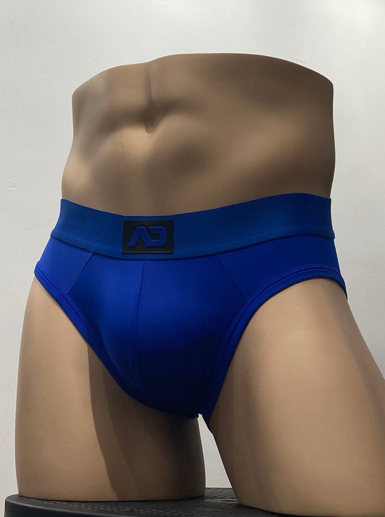 Royal blue stretch brief, as seen from the front. It has a royal blue waistband with a brand emblem on it, front and center.