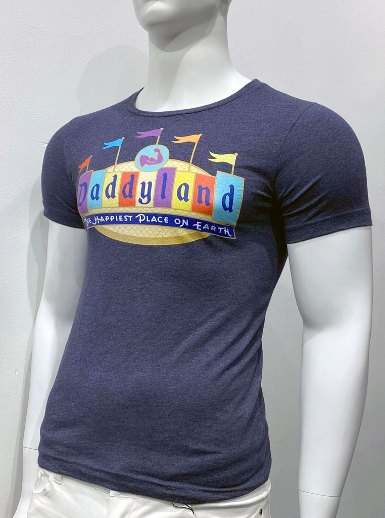 Dark blue T-shirt as seen from the front with a graphic across the chest that looks like a colorful circus tent with five colorful flags flying above it. The word "Daddyland" is featured across the front of this graphic. Below, there is smaller text that reads: "The happiest place on earth."