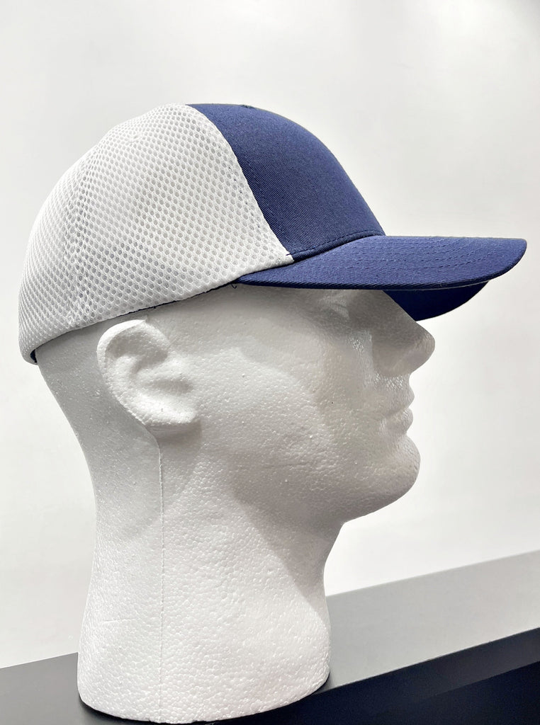   Blue and white fitted baseball cap, from the side. The brim and the front panel of the crown are navy, and back of the crown is made of a white perforated material.