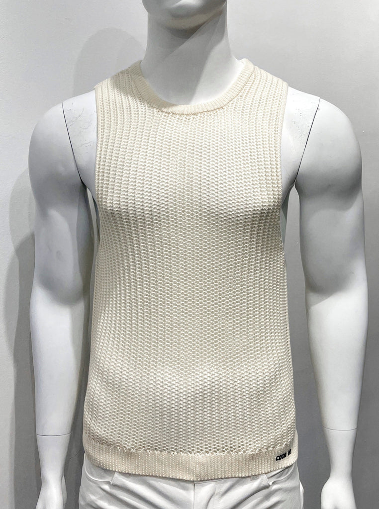 Off-white knit tank top as seen from the front. It is made with an open stitch pattern so it is partially see-through.