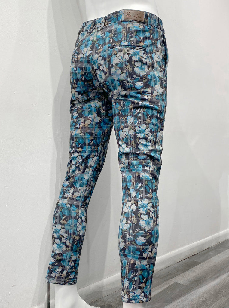 Black slim fit pants covered with vibrant blue hibiscus floral pattern, as seen from the back.