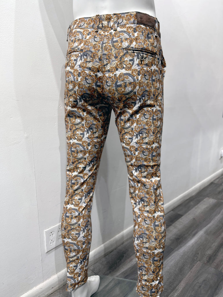 White flat front pants with a dark blue and gold layered ornate pattern, as seen from the back.