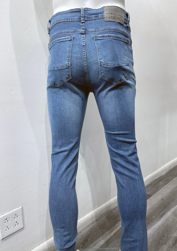 Mid-blue distressed skinny jeans, as seen from the back.