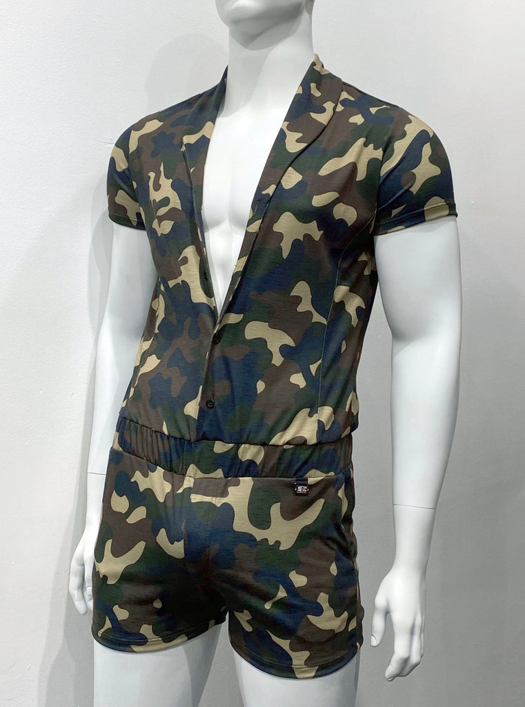 Green camouflage shorts romper as seen from the front, with button-up front, a collar, and an elastic waistband. There are two front pockets.