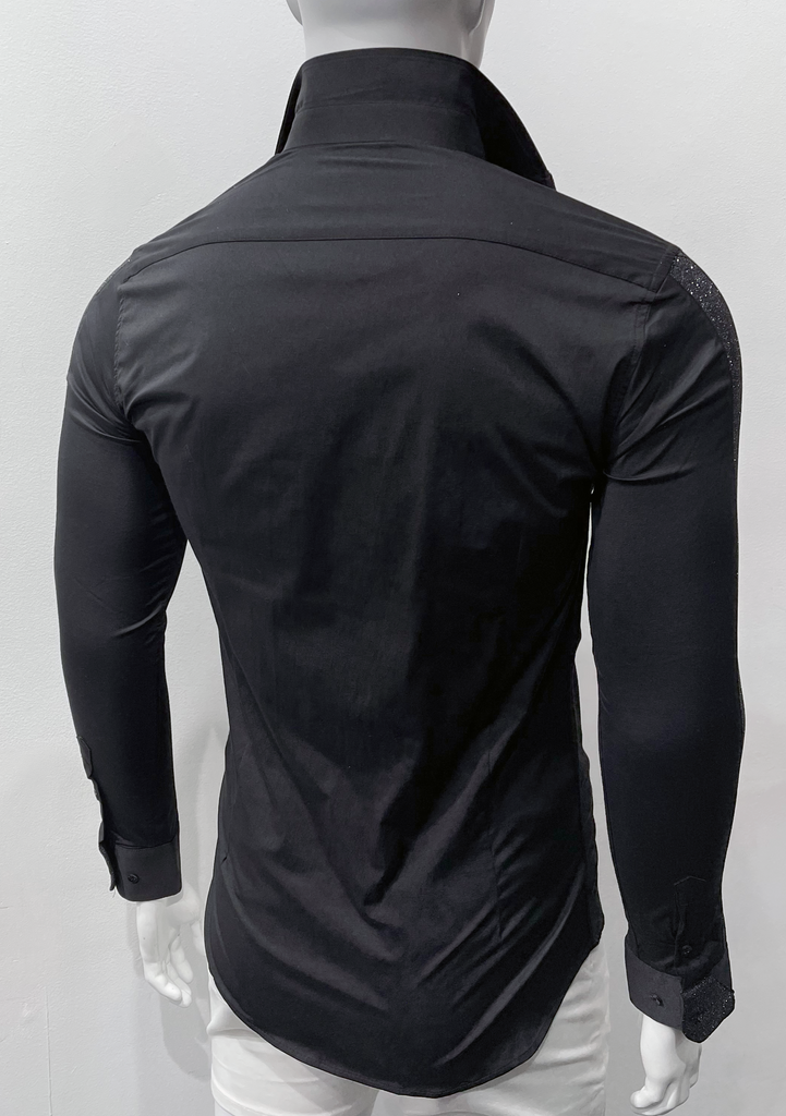 Black button-down, long-sleeved shirt as seen from the back. The right shirt sleeve shoulder and  shirt sleeve cuff has black, sparkly detailing on them.
