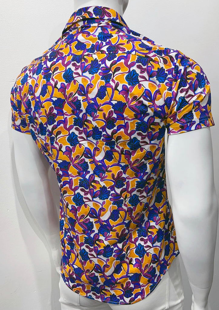 White short-sleeved button-down shirt with a bold amber and violet floral pattern, as seen from the back.