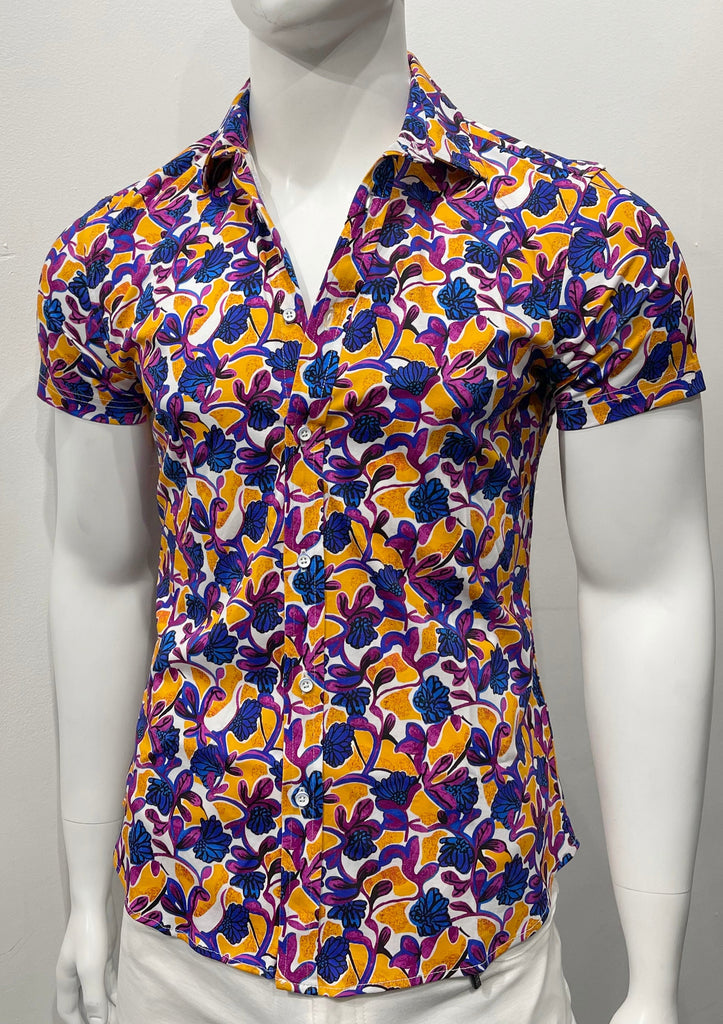 White short-sleeved button-down shirt with a bold amber and violet floral pattern, as seen from the front.