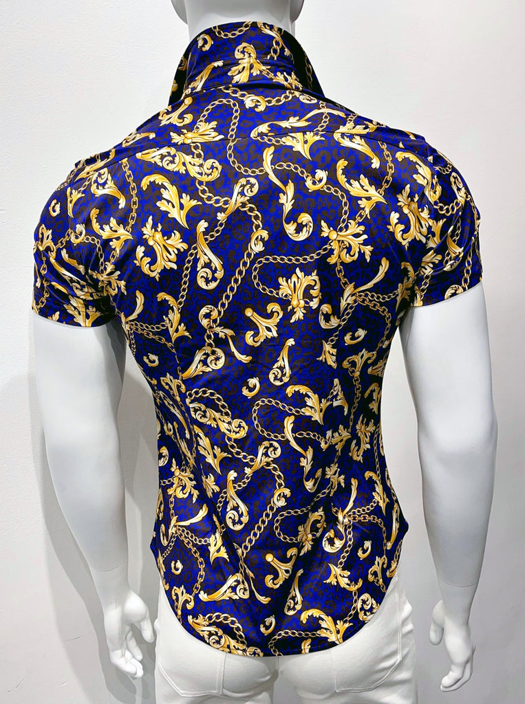 Short-sleeved, button-down collared shirt, as seen from the back. It has graphic, gold deco designs on a dark blue and black cheetah pattern background.