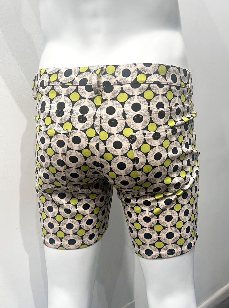 5-pocket stretch knit shorts covered with a pattern of small yellow circles and larger white circles with smaller black circles in the center, as seen from the back.