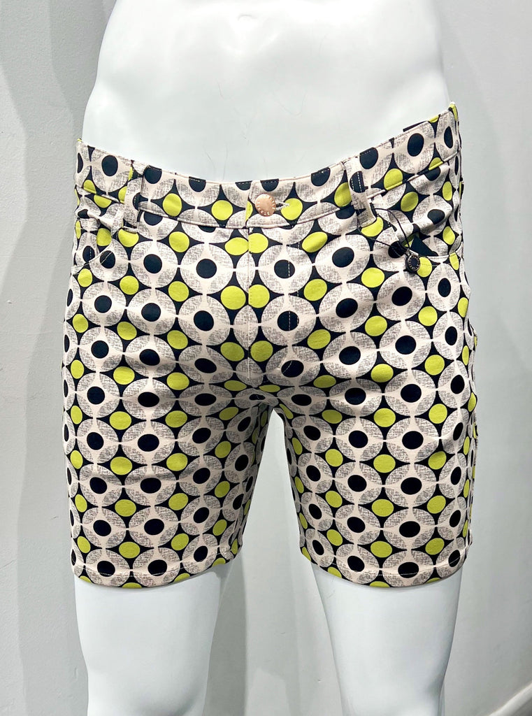 5-pocket stretch knit shorts covered with a pattern of small yellow circles and larger white circles with smaller black circles in the center, as seen from the front.