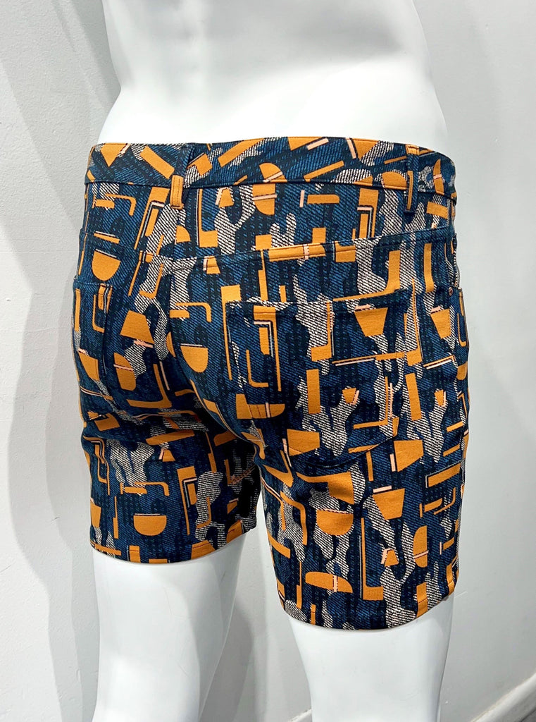 Navy blue 5-pocket stretch knit shorts with an orange, grey and teal pop art pattern, as seen from the back.