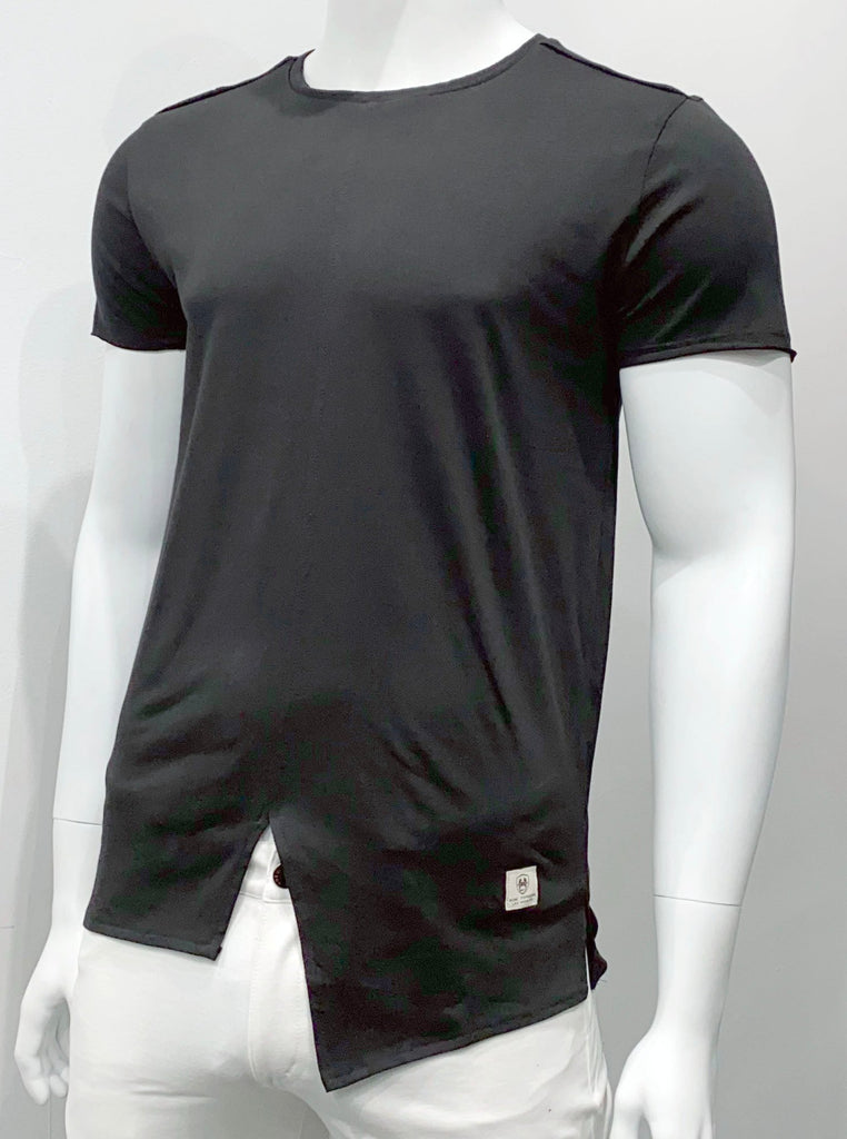 Black T-shirt with an extended torso length and an asymmetrical split hemline in the front, as seen from the front. The hem is split on the sides and about an inch higher in front than in the back.