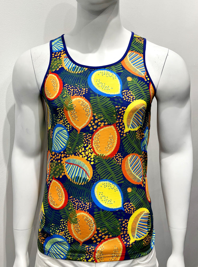 Tank top as seen from the front, with a colorful graphic print comprised of vibrant red, orange, yellow, and green fruits scattered among green ferns and little orange and yellow flowers. There is purple piping on both sides of the shoulder straps.
