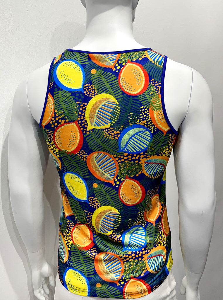 Tank top as seen from the back, with a colorful graphic print comprised of vibrant red, orange, yellow, and green fruits scattered among green ferns and little orange and yellow flowers. There is purple piping on both sides of the shoulder straps.