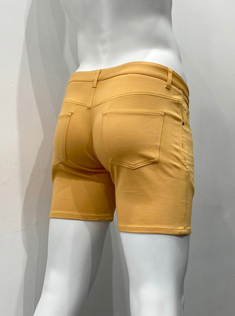 Apricot-peel-colored 5-pocket stretch knit shorts, as seen from the back.