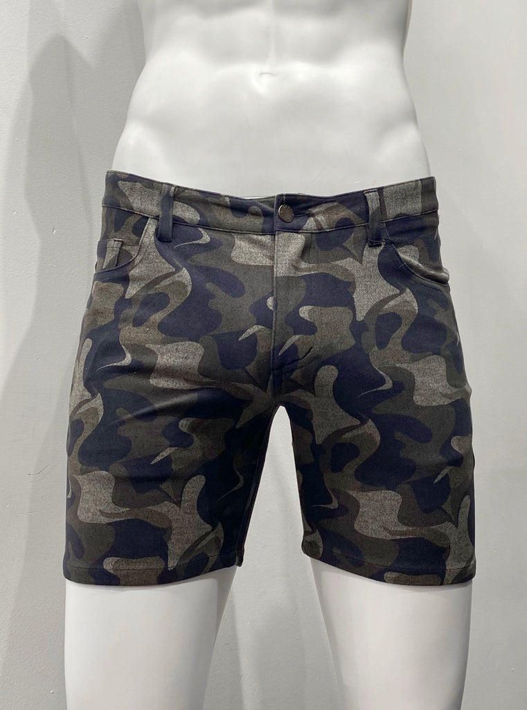 Green camouflage, zip-front, 5-pocket stretch knit shorts, as seen from the front. The green camouflage pattern includes black, army green, khaki green and khaki tan colors.