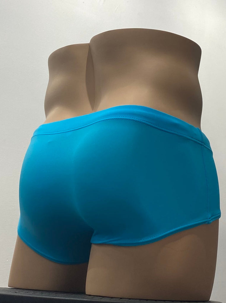 Turquoise sunga swim brief as seen from the front, with a brand emblem on the waistband above the left hip.