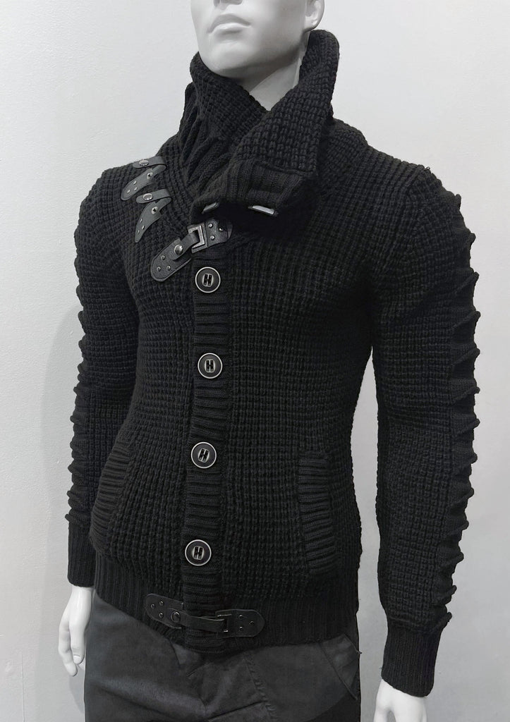Black high-collared cardigan sweater as seen from the front, with large grey buttons, a grey leather latch and strap fastener in place of the top button, two grey leather straps and latch details on the right breast, and a grey latch and strap detail center-front along the hem.