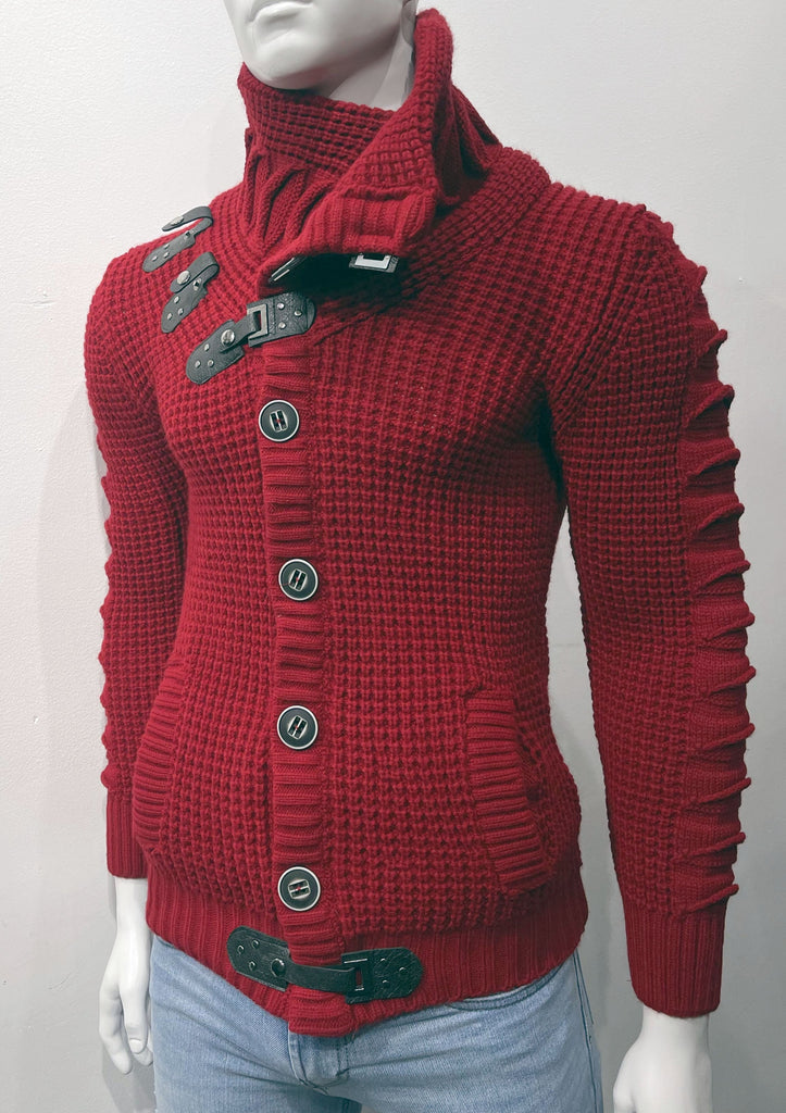 Dark red high-collared cardigan sweater as seen from the front, with large grey buttons, a grey leather latch and strap fastener in place of the top button, two leather straps and latch details on the right breast, and grey latch and strap detail center-front along the hem.