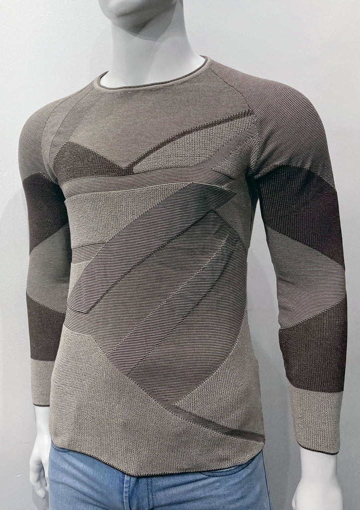 Slim fit crew neck sweater covered with an angular patchwork pattern of light and dark browns and varying weave textures, as seen from the front.