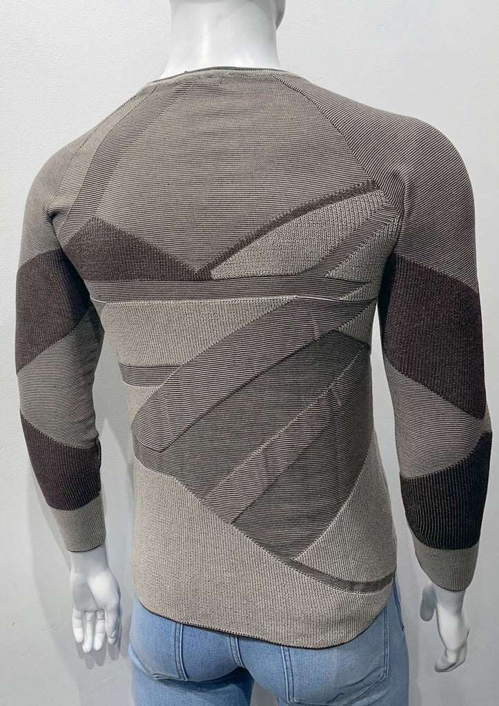 Slim fit crew neck sweater covered with an angular patchwork pattern of light and dark browns and varying weave textures, as seen from the back.
