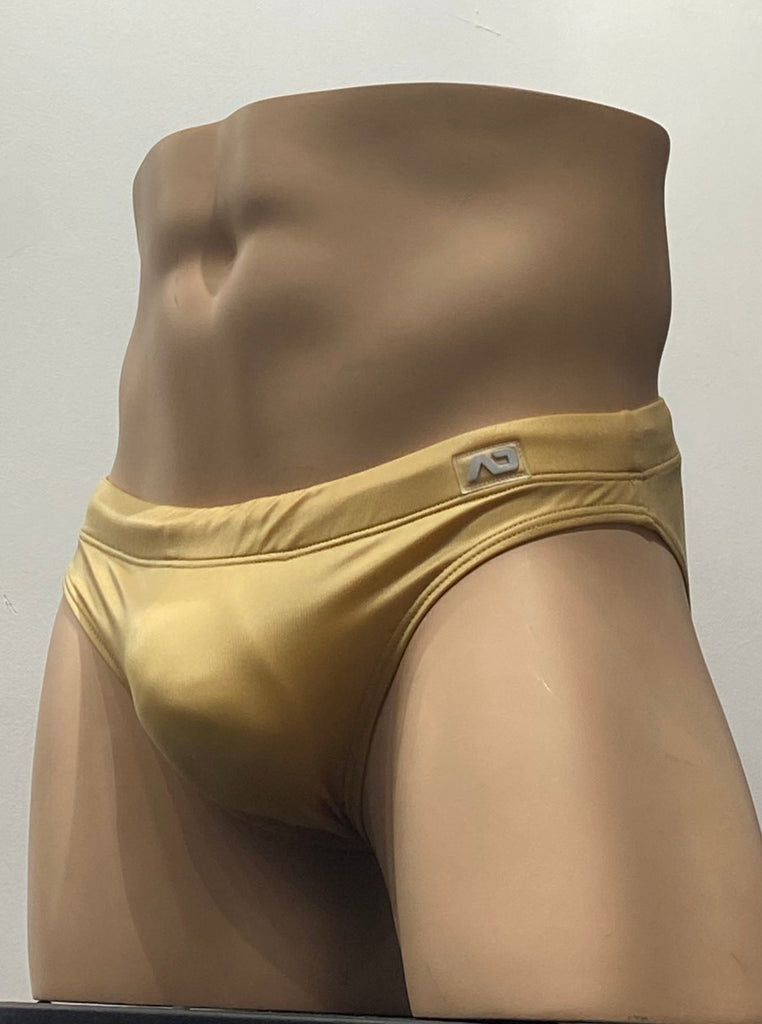  Gold swim brief as seen from the front, with a grey brand emblem on the waistband above the left hip.