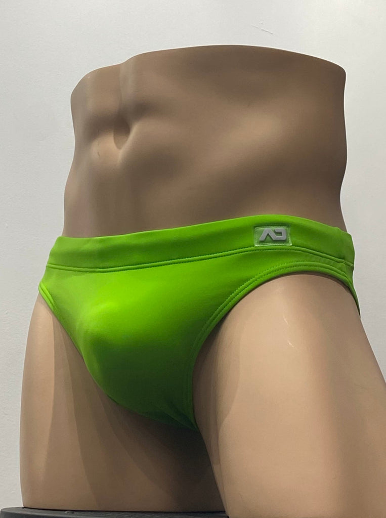 Lemon green swim brief as seen from the front, with a grey brand emblem on the waistband above the left hip.