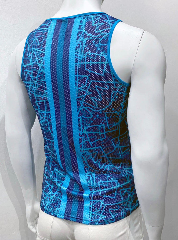 Perforated mesh tank to as seen from the back, with a pattern of dark and light turquoise and teal angular shapes, squiggle lines and dots over a navy background. There is turquoise piping on the shoulder straps and around the neck. There is a thick vertical stripe going up the center of the back panel. This stripe is comprised of five thinner vertical stripes. The two outermost stripes are turquoise, the two second outermost strips are navy, and the single inner stripe is teal.
